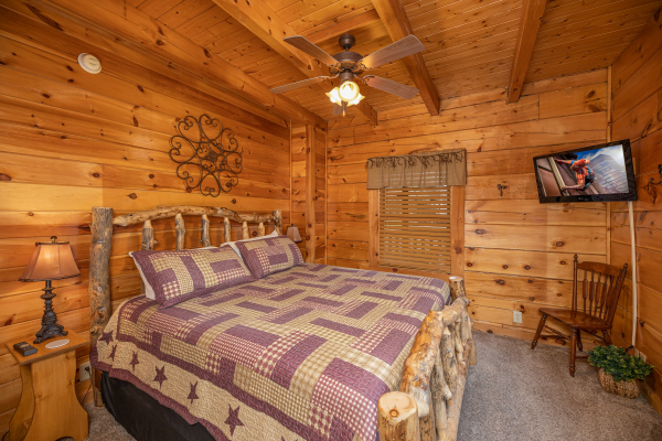 Bedroom with bed, night stands, lamps, and TV at Livin' Simple, a 2 bedroom cabin rental located in Pigeon Forge 