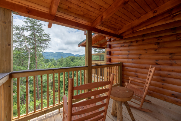 Rocking chairs on a covered porch at Sawmill Springs, a 3 bedroom rental cabin in Pigeon Forge