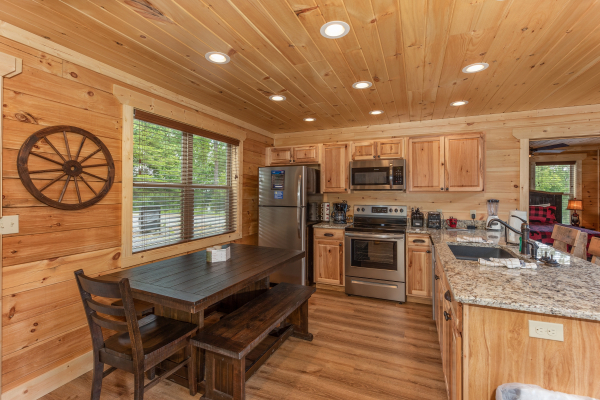 Large dining table in the stainless steel kitchen at Sawmill Springs, a 3 bedroom cabin rental located in Pigeon Forge