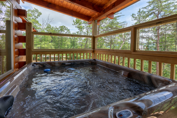 Hot tub on a covered deck at Sawmill Springs, a 3 bedroom rental cabin in Pigeon Forge