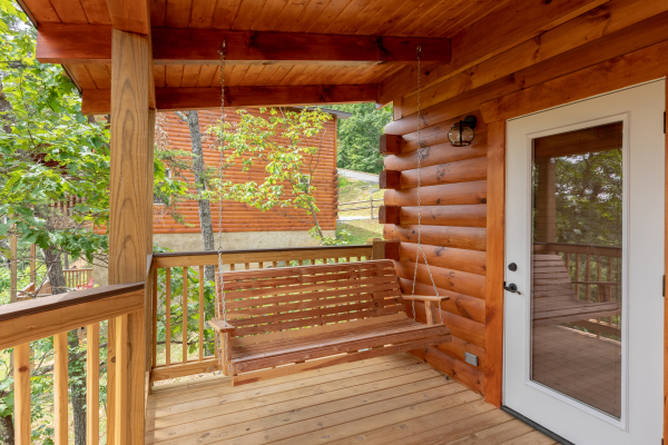 Swing on a covered porch at Sawmill Springs, a 3 bedroom rental cabin in Pigeon Forge