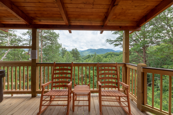 Rocking chairs on a covered deck at Sawmill Springs, a 3 bedroom rental cabin in Pigeon Forge