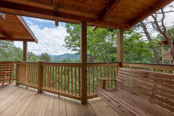 Swing and view from the covered porch at Sawmill Springs, a 3 bedroom rental cabin in Pigeon Forge