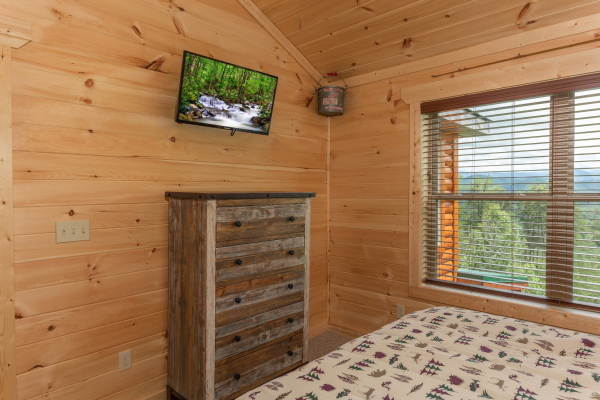 TV and dresser in a bedroom at Sawmill Springs, a 3 bedroom rental cabin in Pigeon Forge