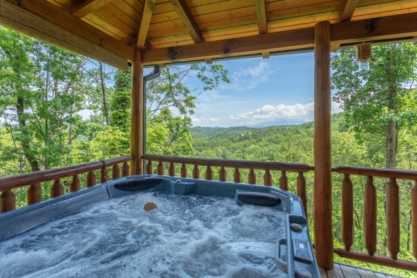 Hot tub views on the covered porch at Mountain Adventure, a 2 bedroom cabin rental located in Pigeon Forge