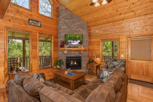 Living room with stone fireplace and TV at Mountain Adventure, a 2 bedroom cabin rental located in Pigeon Forge