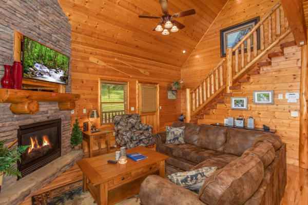 Living room with sectional sofa, fireplace, and TV at Mountain Adventure, a 2 bedroom cabin rental located in Pigeon Forge