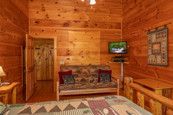Futon in the loft bedroom with a tv at Misty Mountain Escape, a 2 bedroom cabin rental located in Gatlinburg