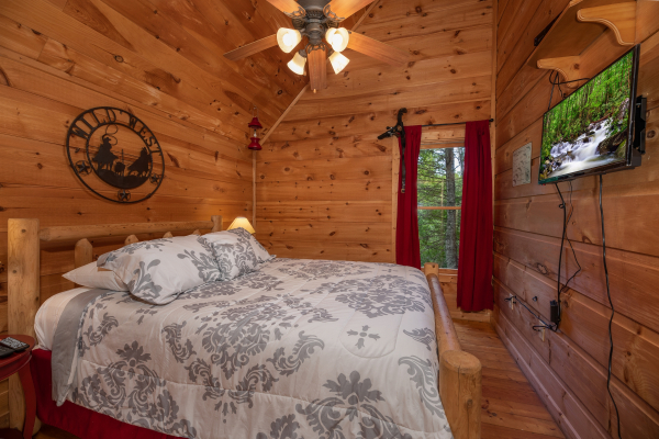 Bedroom with a king bed and TV at Logan's Smoky Den, a 2 bedroom cabin rental located in Pigeon Forge