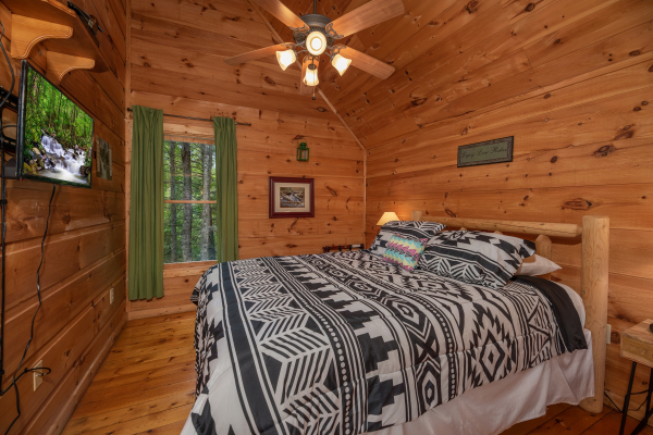 Bedroom with king bed and TV at Logan's Smoky Den, a 2 bedroom cabin rental located in Pigeon Forge