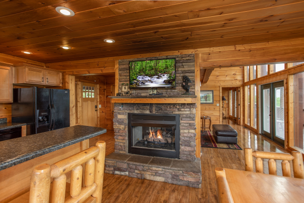 Fireplace and TV in the dining room at Mountain Bliss, a 2 bedroom cabin rental located in Pigeon Forge