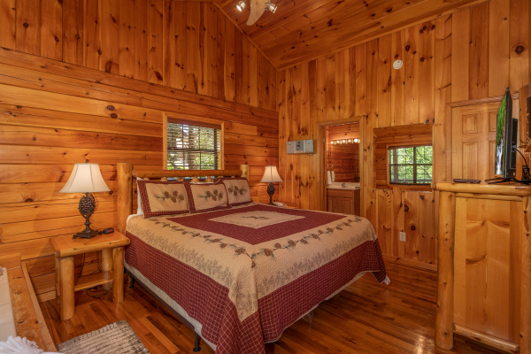 King bedroom with end tables, lamps, and a TV at Hello Dolly, a 1 bedroom cabin rental located in Pigeon Forge
