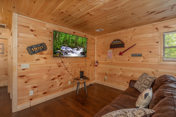 Large wall mounted TV in the game room at Always Dream'n, a 6 bedroom cabin rental located in Pigeon Forge
