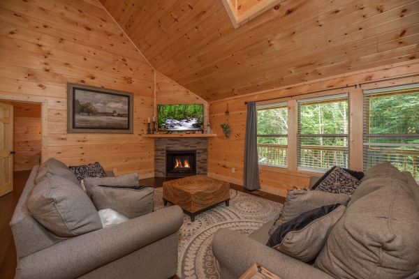 Vaulted living room with fireplace and TV at Always Dream'n, a 6 bedroom cabin rental located in Pigeon Forge