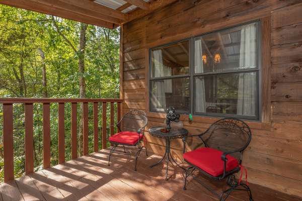 Bistro set on a covered deck at Misty Mountain Sunrise, a 3 bedroom cabin rental located in Pigeon Forge