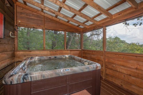 Hot tub on a screened in porch at Misty Mountain Sunrise, a 3 bedroom cabin rental located in Pigeon Forge