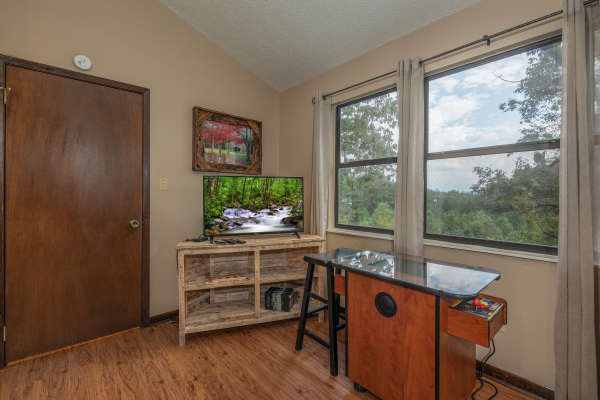 TV and arcade game in the game loft at Misty Mountain Sunrise, a 3 bedroom cabin rental located in Pigeon Forge