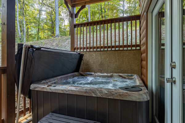 Hot tub on a covered deck at Gar Bear's Hideaway, a Pigeon Forge cabin rental