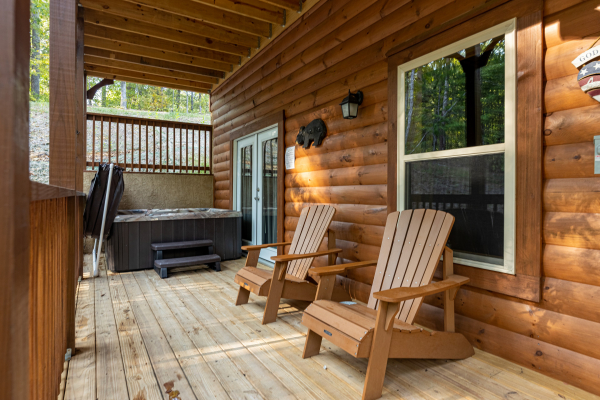 Hot tub and adirondack chairs on a deck at Gar Bear's Hideaway, a Pigeon Forge cabin rental