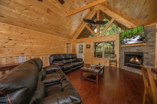 Sofa, loveseat, fireplace, and tv in a living room at Gar Bear's Hideaway, a 3 bedroom cabin rental located in Pigeon Forge