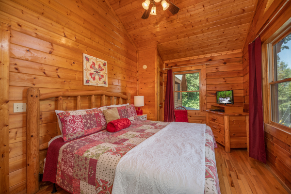 Bedroom with a log bed, dresser, and TV at Majestic Mountain, a 4 bedroom cabin rental located in Pigeon Forge