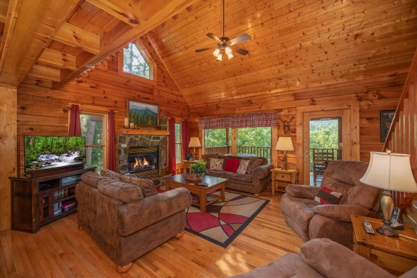Living room with vaulted ceiling, fireplace, TV, and seating at Majestic Mountain, a 4 bedroom cabin rental located in Pigeon Forge