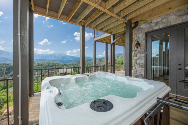 Hot tub on a covered deck at Mountain Celebration, a 4 bedroom cabin rental located in Gatlinburg
