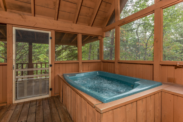 Hot tub on a covered deck at Yes, Deer, a 2 bedroom cabin rental located in Pigeon Forge