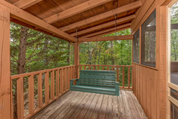 Porch swing on a covered deck at Yes, Deer, a 2 bedroom cabin rental located in Pigeon Forge