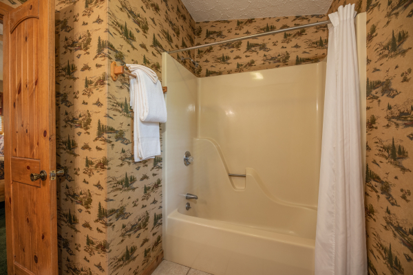 Tub and shower in a bathroom at Yes, Deer, a 2 bedroom cabin rental located in Pigeon Forge