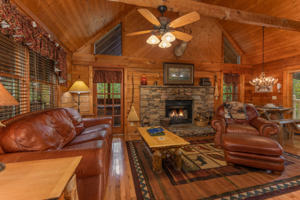 Fireplace and leather sofa and leather chair at Yes, Deer, a 2 bedroom cabin rental located in Pigeon Forge