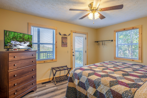 TV, dresser, and deck access in a bedroom at Le Bear Chalet, a 7 bedroom cabin rental located in Gatlinburg