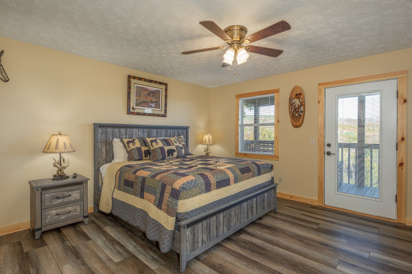 Bedroom with two night stands and lamps and deck access at Le Bear Chalet, a 7 bedroom cabin rental located in Gatlinburg