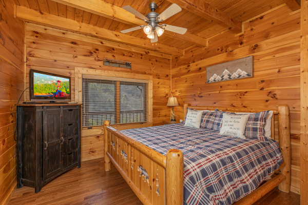 King bed and armoire with TV in a bedroom at Mountain Mama, a 3 bedroom cabin rental located in Pigeon Forge