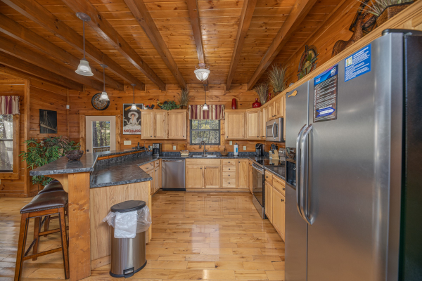 Kitchen with island breakfast bar and stainless appliances at King of the Mountain, a 3 bedroom cabin rental located in Pigeon Forge