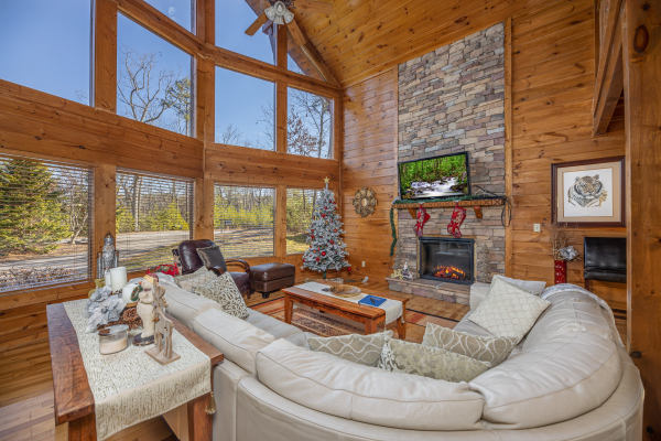 Large windows, fireplace, and TV in the living room at King of the Mountain, a 3 bedroom cabin rental located in Pigeon Forge