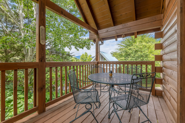 Deck dining for four at Logged Inn, a 3 bedroom cabin rental located in Pigeon Forge