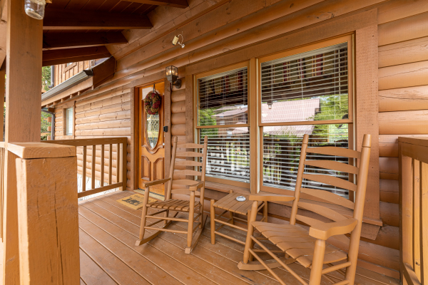 Rocking chairs on a covered front porch at Logged Inn, a 3 bedroom cabin rental located in Pigeon Forge
