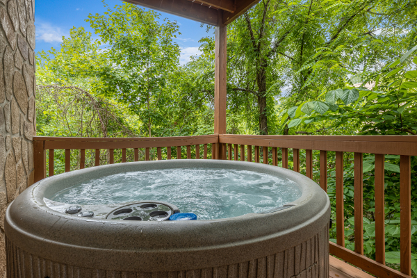 Hot tub on a covered deck at Logged Inn, a 3 bedroom cabin rental located in Pigeon Forge