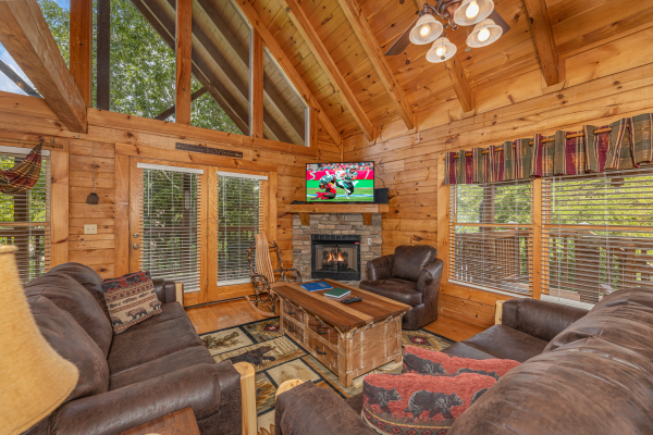 Fireplace, TV, and seating in a living room at Logged Inn, a 3 bedroom cabin rental located in Pigeon Forge