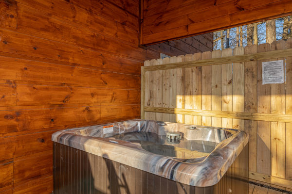 Hot tub on a covered deck with privacy fence at Bessy Bears Cabin, a 2 bedroom cabin rental located inGatlinburg