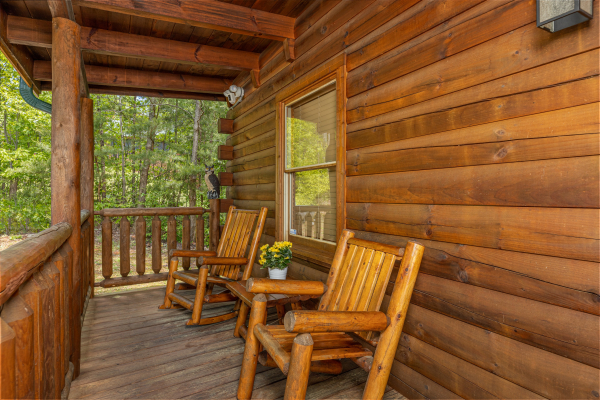 Deck chairs on a covered porch at Moonlit Pines, a 2 bedroom cabin rental located in Pigeon Forge