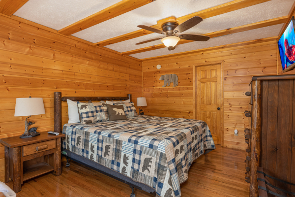 Bedroom with two night stands, lamps, dresser, and TV at Pool Side Lodge, a 6 bedroom cabin rental located in Pigeon Forge