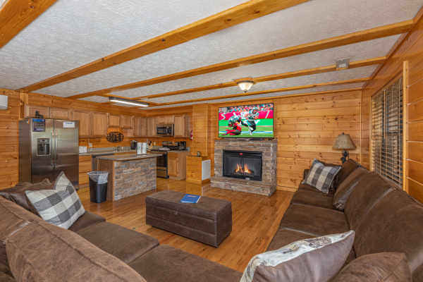 Living room with fireplace and TV at Pool Side Lodge, a 6 bedroom cabin rental located in Pigeon Forge