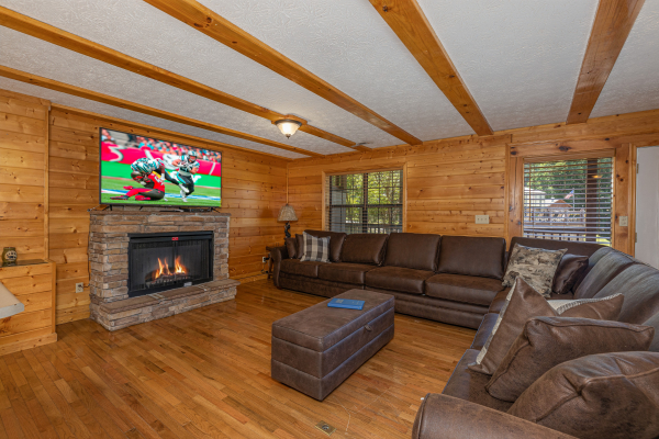 Fireplace, TV, and two sofas in the living room at Pool Side Lodge, a 6 bedroom cabin rental located in Pigeon Forge