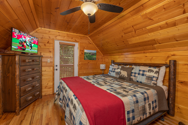 King bed, dresser, TV, and deck access in a bedroom at Pool Side Lodge, a 6 bedroom cabin rental located in Pigeon Forge