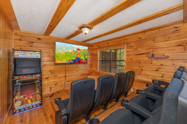 Theater room and arcade game at Pool Side Lodge, a 6 bedroom cabin rental located in Pigeon Forge