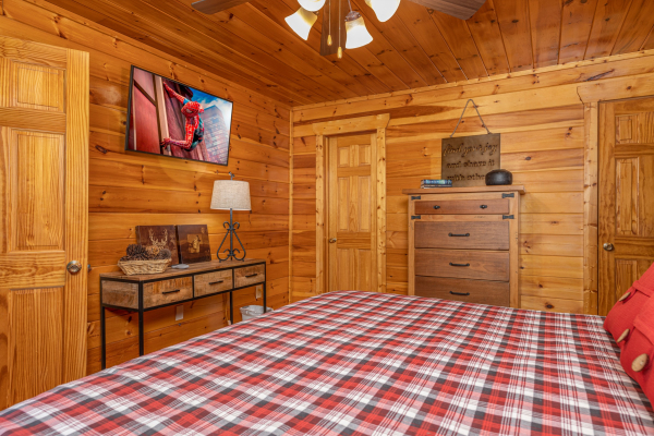 Dresser, TV, and table in a bedroom at Whispering Grace, a 2 bedroom cabin rental located in Gatlinburg