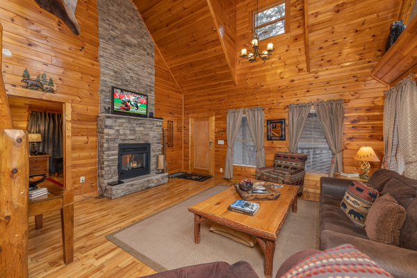 TV, fireplace, and seating in a living room at Whispering Grace, a 2 bedroom cabin rental located in Gatlinburg