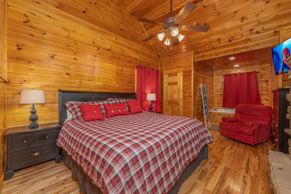 Bedroom wiht a king bed, two night stands, lamps, and a chair at Whispering Grace, a 2 bedroom cabin rental located in Gatlinburg